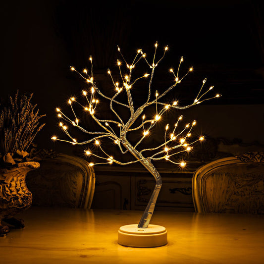 A tree-shaped light placed on a living room table glowing.