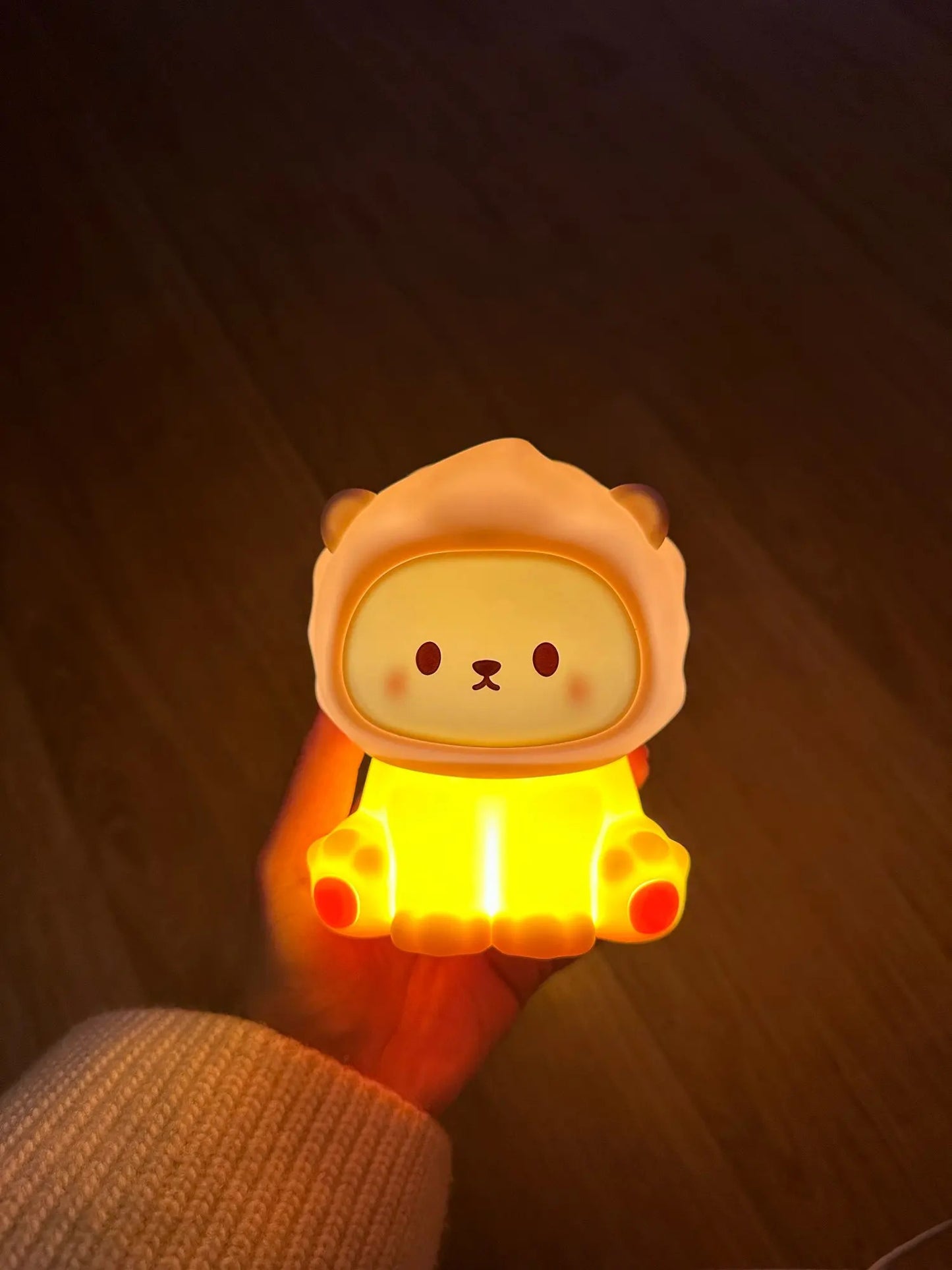 A person holding a cute lion-shaped lamp.