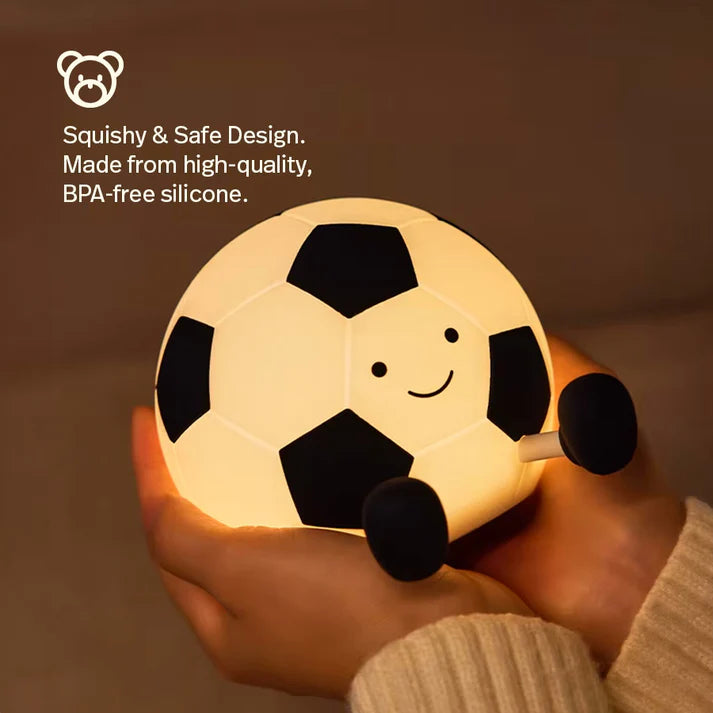 A person holding in his hands a football-shaped night light.